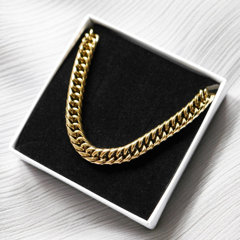 Gold chain necklace in a white box on a white surface